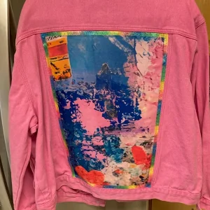 Pink denim jacket with upcycled abstract design.